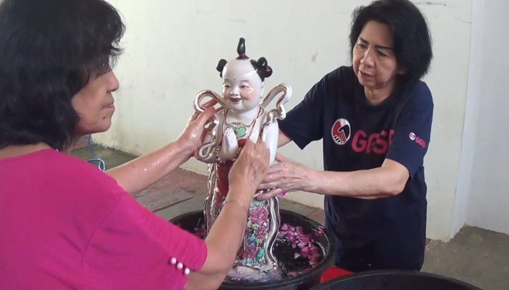 Umat tri dharma Kelenteng Poo Tong Bio membersihkan patung.(Fatur Bari/mili.id)