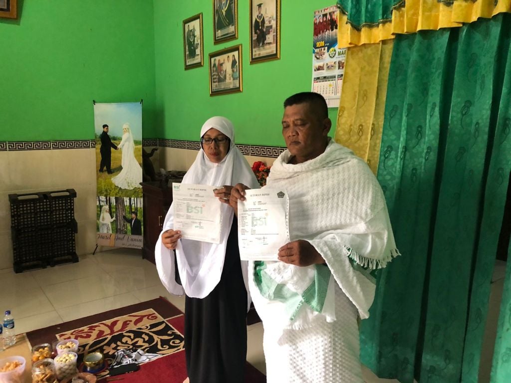 Pasangan suami istri Dasuki dan Yasmiati jemaah calon haji menunjukan bukti pelunasan haji di kediamannya (Foto : Nana/mili.id)