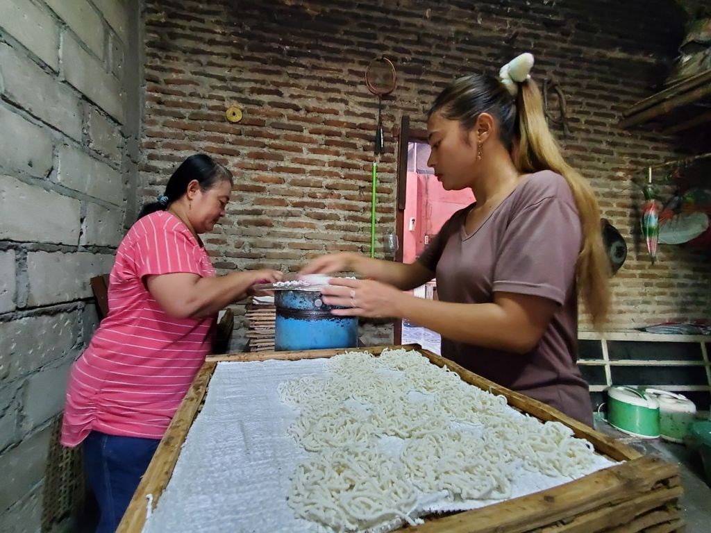 Ratnawati (47) bersama anak sulungnya sudah sejak pukul 04.45 WIB mulai melakukan proses produksi akar kelapa atau dikenal masyarakat Jawa jajanan pertulo hingga pukul 10.00 WIB setiap harinya (Foto: Nana/mili.id)