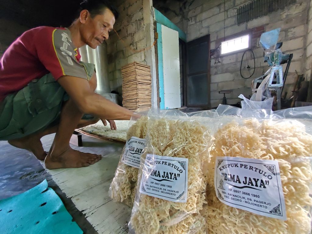 Salikin (52) menata pertulo yang sudah siap dijemur di bawah terik matahari (Foto: Nana/mili.id)